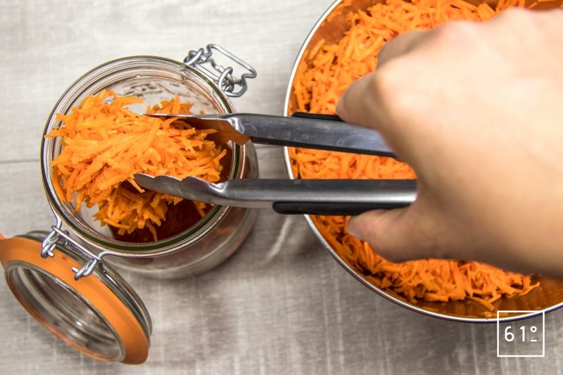 Remplir le pot du mélange de carottes râpées, d'ail et de sel qui a macéré