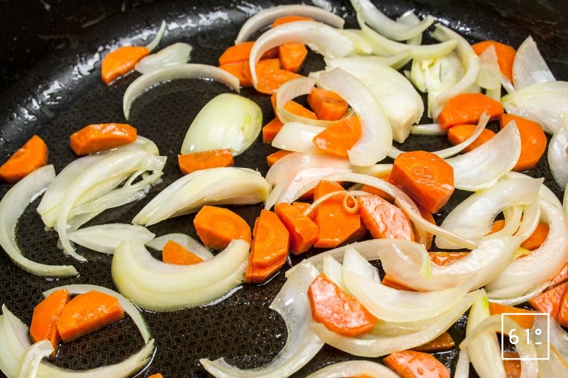 Cuire les oignons émincés et les morceaux de carotte dans une poêle avec un peu de beurre